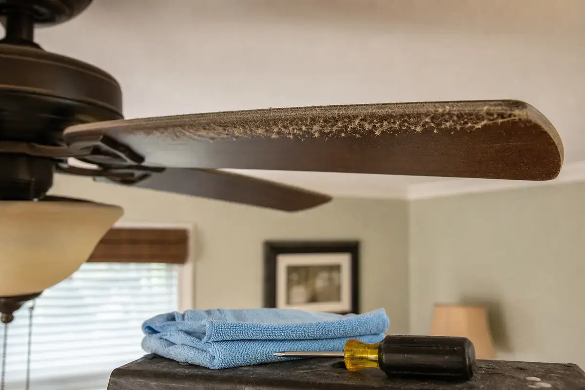 Dusty ceiling fan blade checked for slow or weak airflow