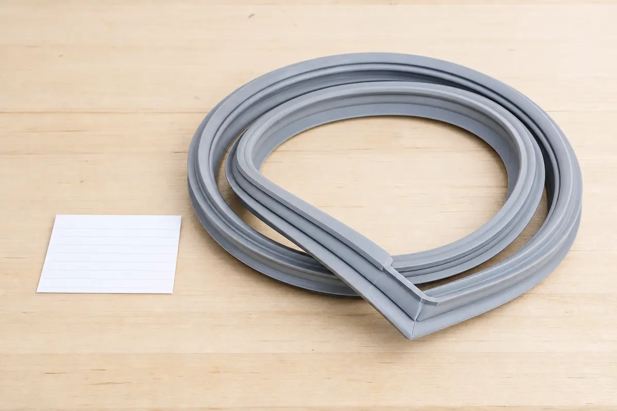 Model-neutral replacement refrigerator door gasket with molded corner profile