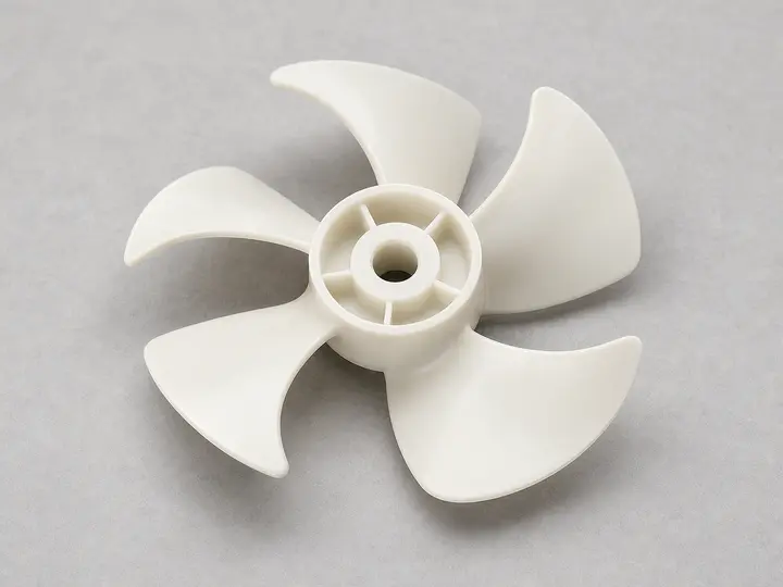 Off-white refrigerator fan blade with central hub