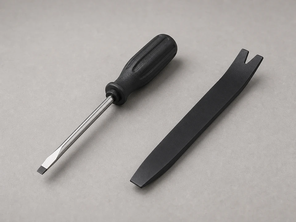 Plastic pry tool lifting a trim cap from a casement window lock handle