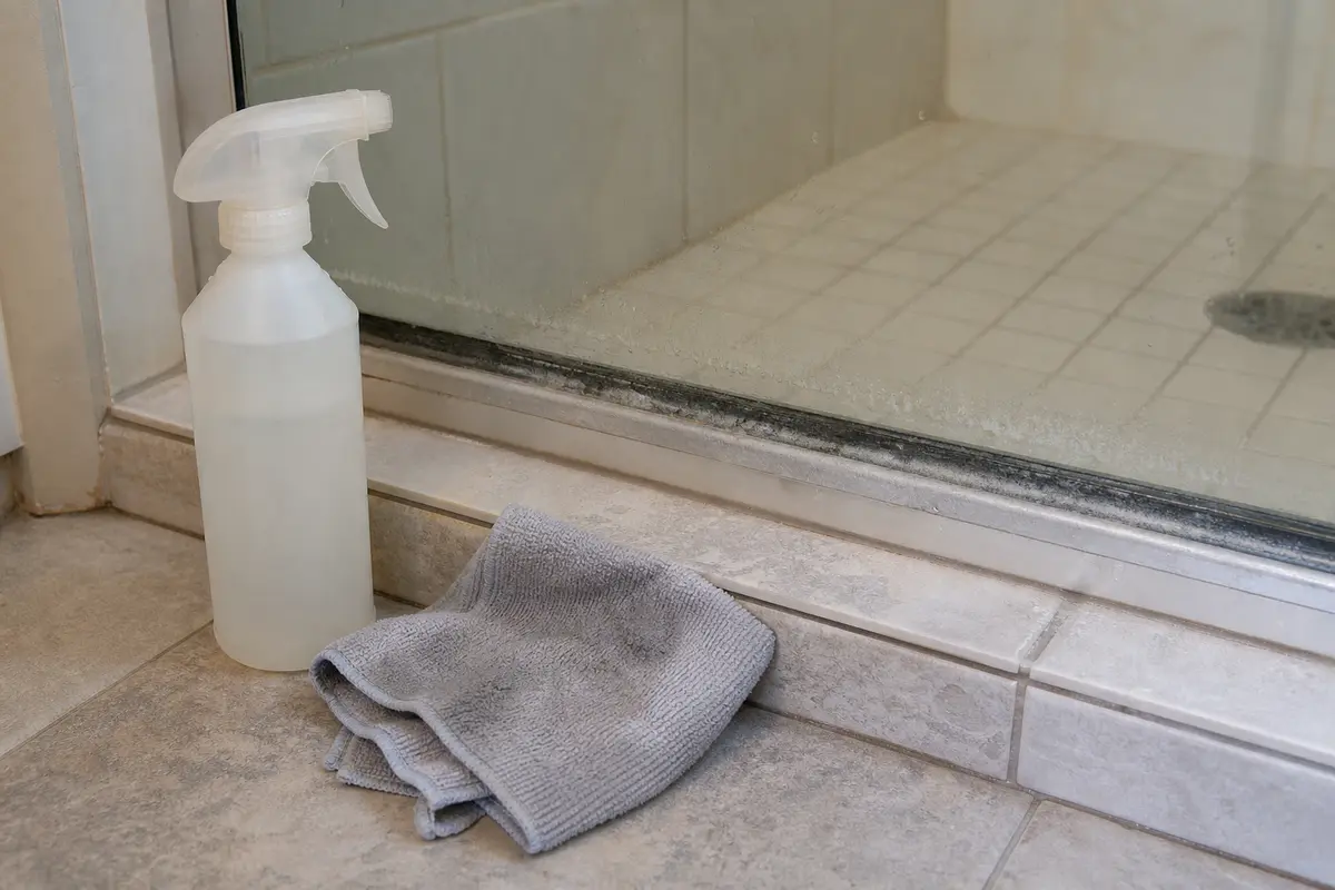 Mild bathroom cleaner for removing soap scum from the shower door bottom edge